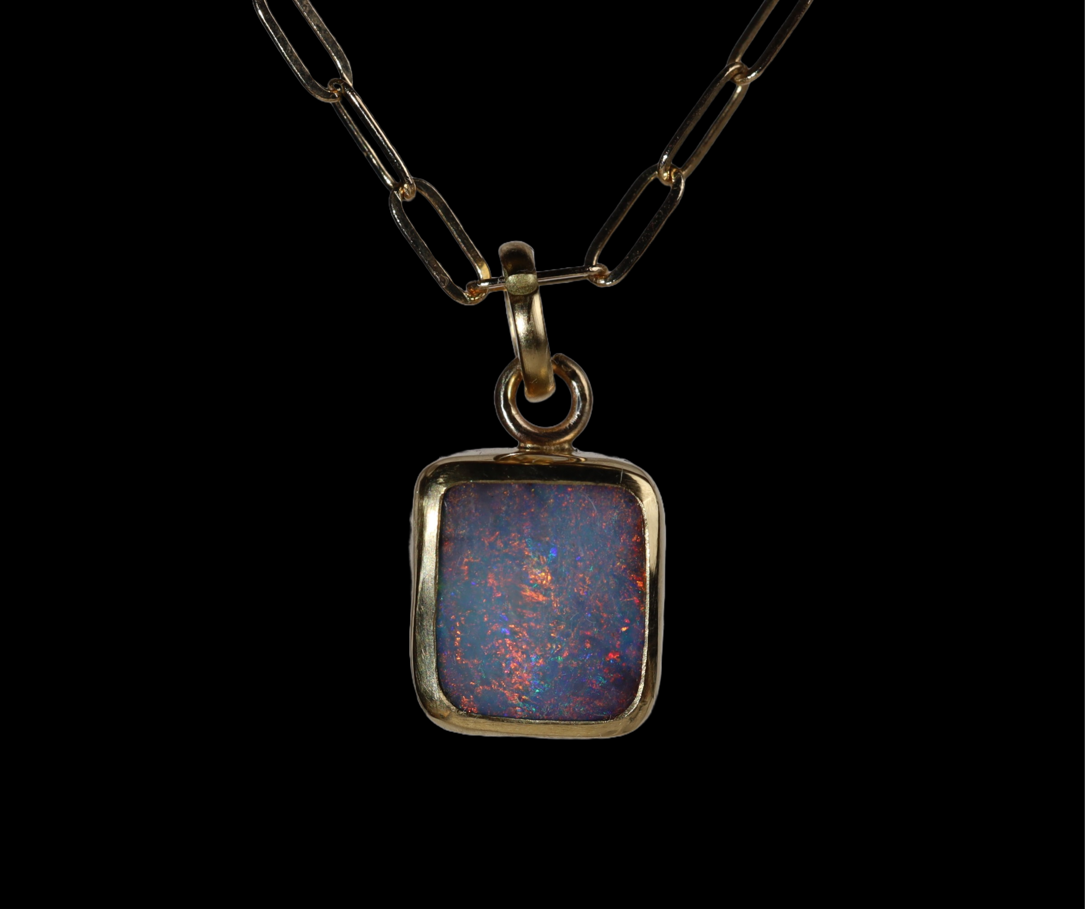 Front view of rectangular shaped opal  pendant with red and blue sparkle.