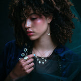 Model wearing crescent moon earring along with other jewelry.