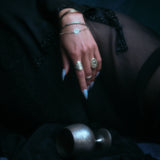 Model's hand wearing the 14k yellow gold bangle along with other jewelry.