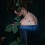 Model wearing handmade paperclip chain and small charm holder, with opal and diamond pendant attached along with other jewelry.