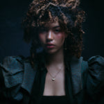 Model wearing crescent moon earring along with other jewelry.