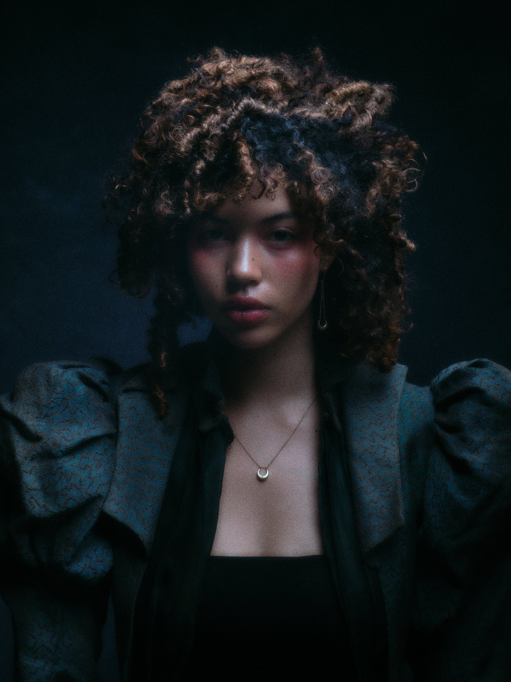 Model wearing crescent moon earring along with other jewelry.