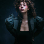 Model wearing crescent moon earring along with other jewelry.