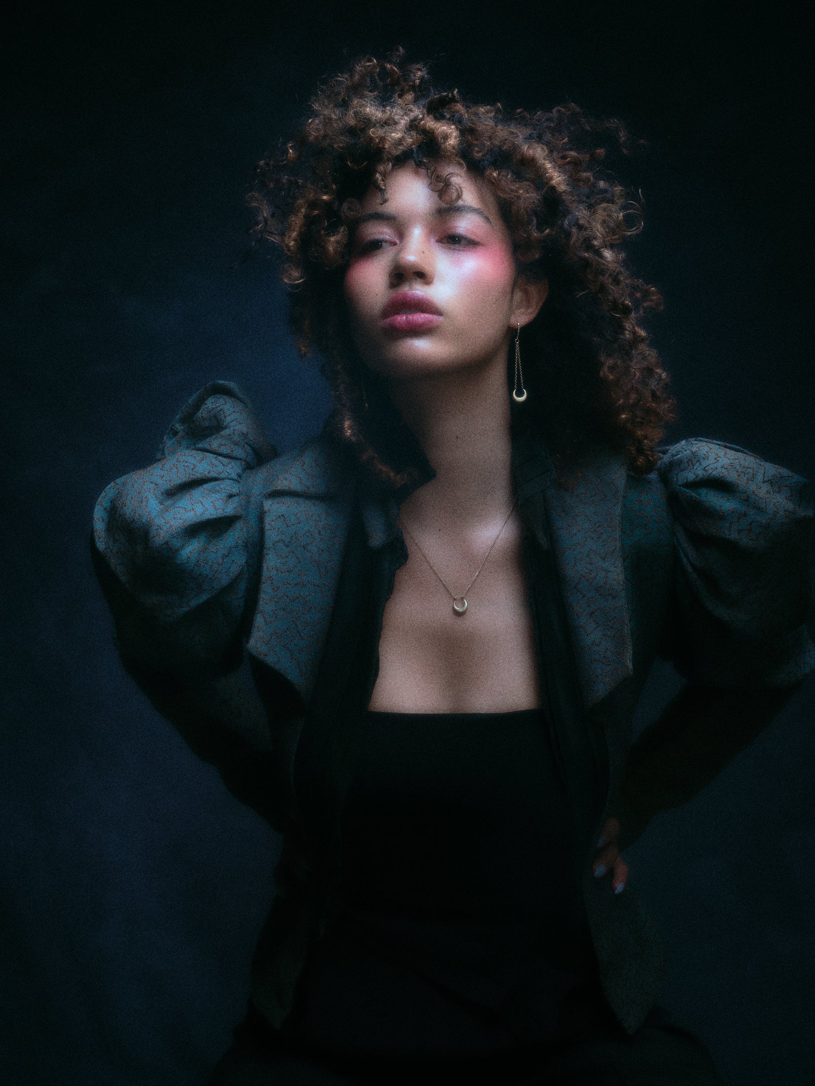 Model wearing crescent moon earring along with other jewelry.