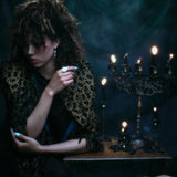 Models wearing 18k hand-engraved diamond moon ring along with other jewelry in front of a dark backdrop and gothic candles.