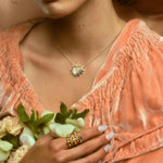 Model wearing stack of five hydria inspired rings on pointer finger and a heart pendant necklace.