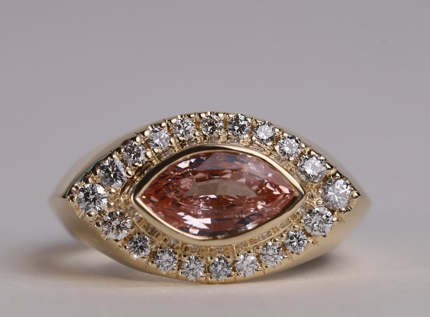 Gold ring with arquise cut sapphire surrounded by diamonds.