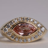 Gold ring with arquise cut sapphire surrounded by diamonds.