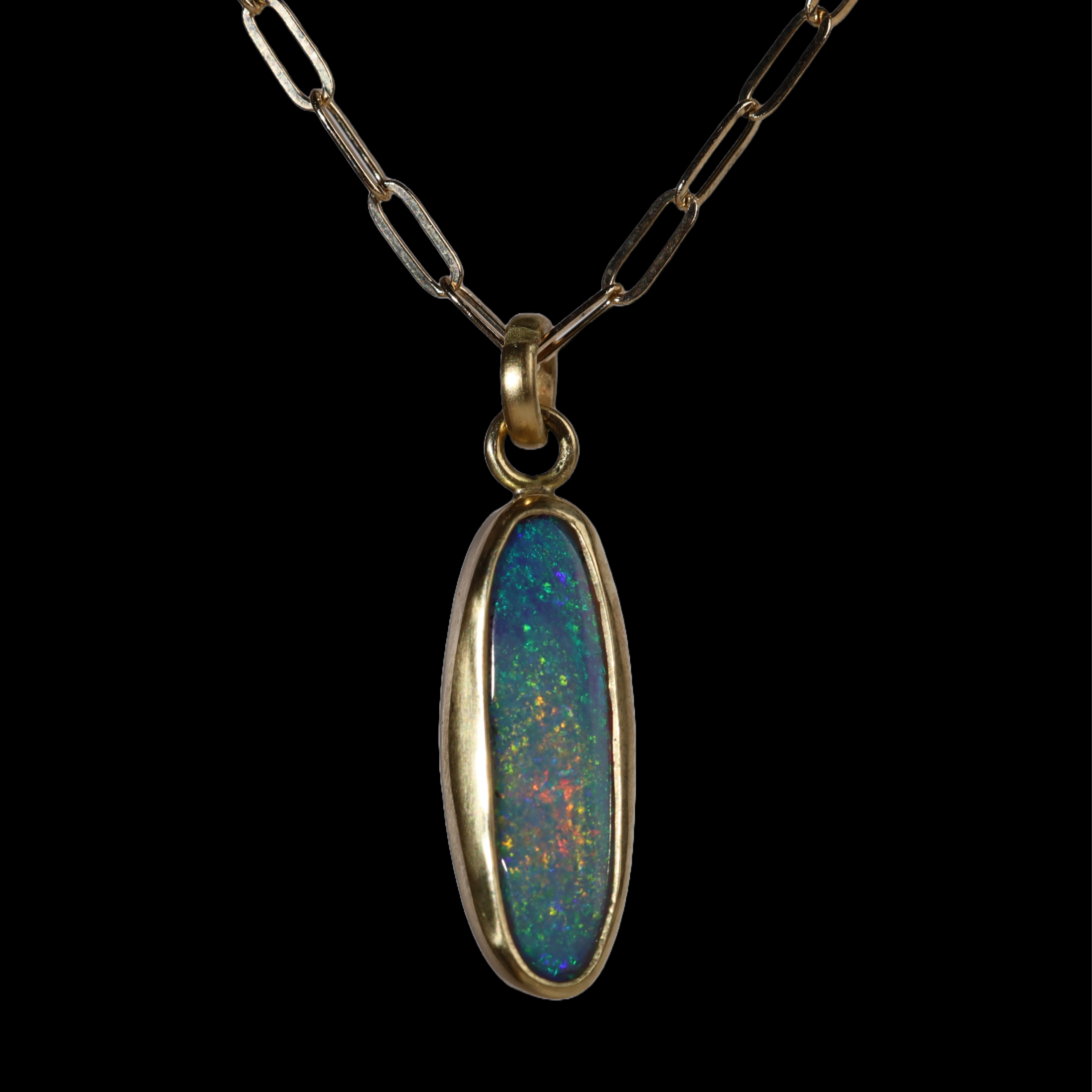 Front view of tall oval pendant with green, blue, and red sparkle.