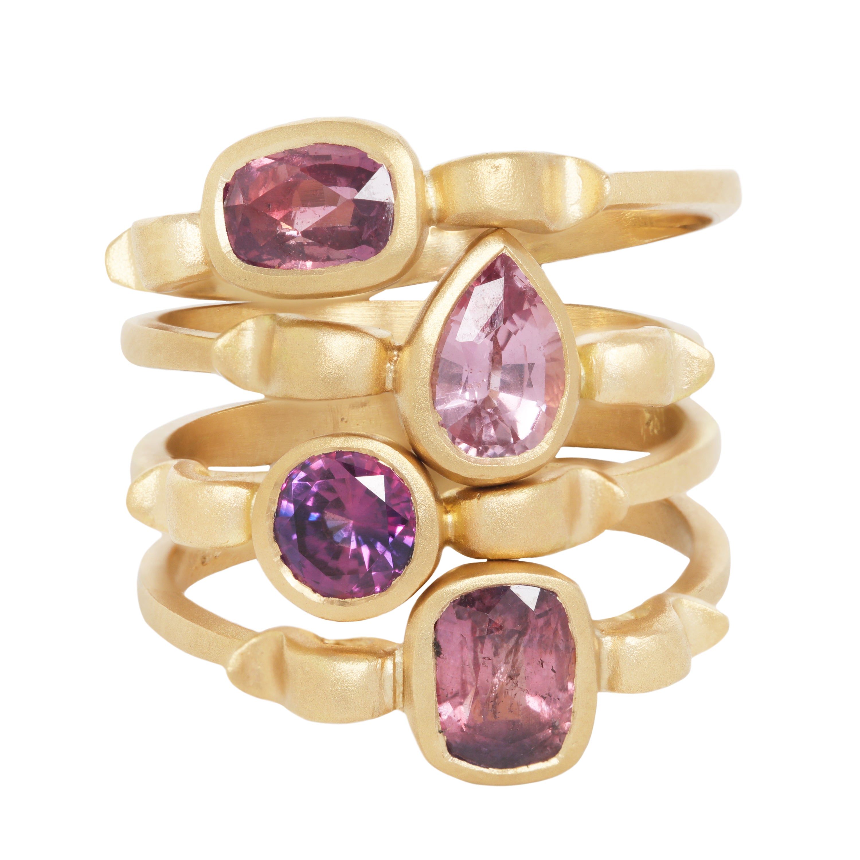 Stack of 4 yellow gold rings each with shapes inspired  by the greek hydria.