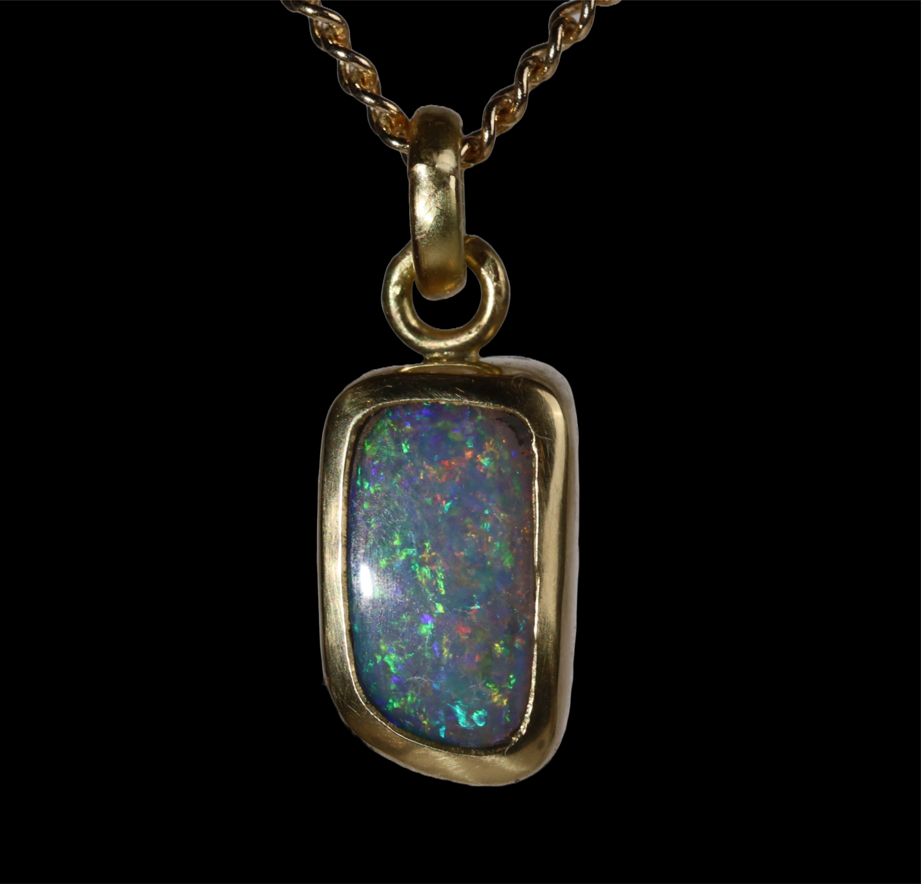 Front view of rectangular opal  pendant with green, red, and blue sparkle.