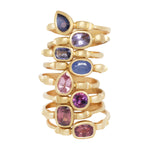 Stack of 8 yellow gold rings each with shapes inspired  by the greek hydria.