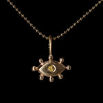 Gold pendant with a yellow gemstone on a black background