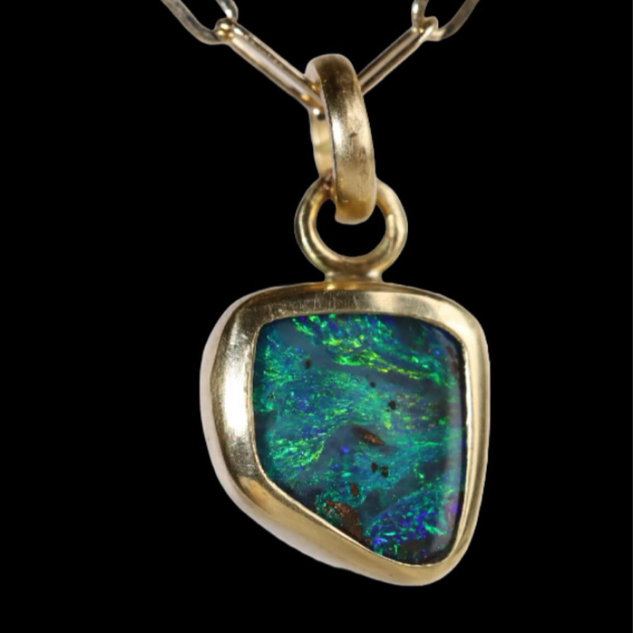 Front view of oval pendant with green and blue sparkle.