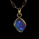 Front view of diamond shaped opal  pendant with green and blue sparkle.