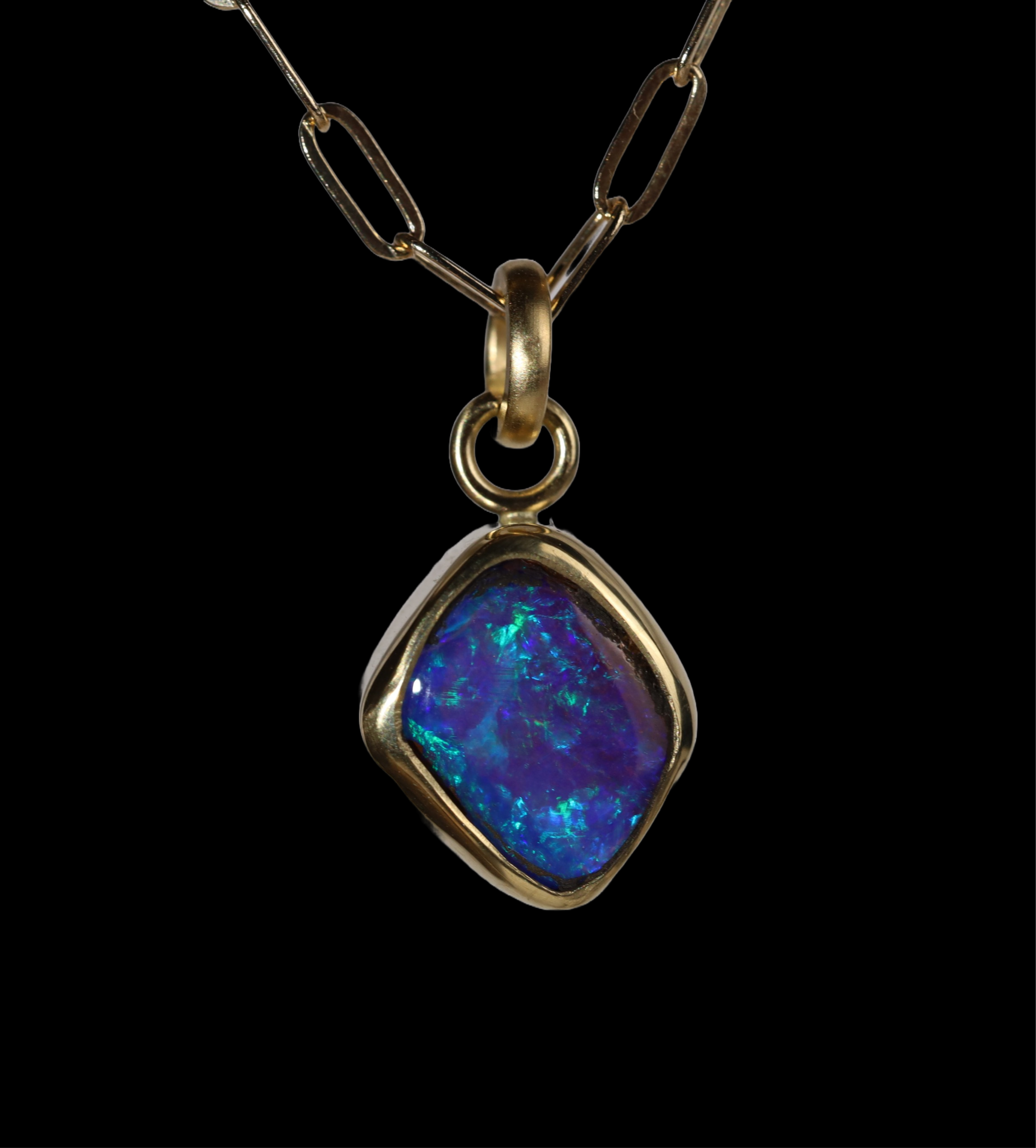 Front view of diamond shaped opal  pendant with green and blue sparkle.