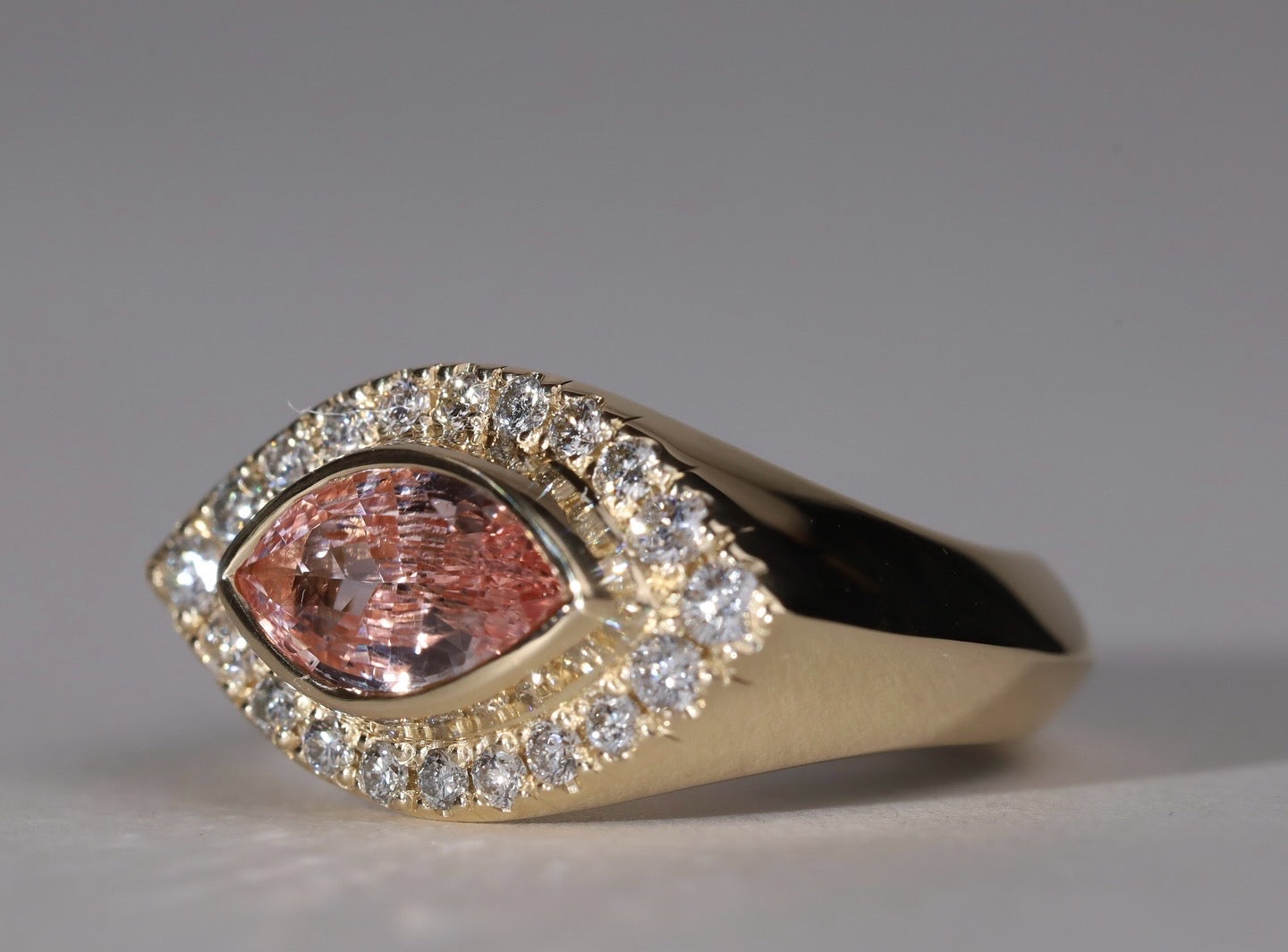 Gold ring with arquise cut sapphire surrounded by diamonds.