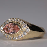 Gold ring with arquise cut sapphire surrounded by diamonds.