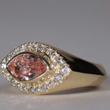 Gold ring with arquise cut sapphire surrounded by diamonds.