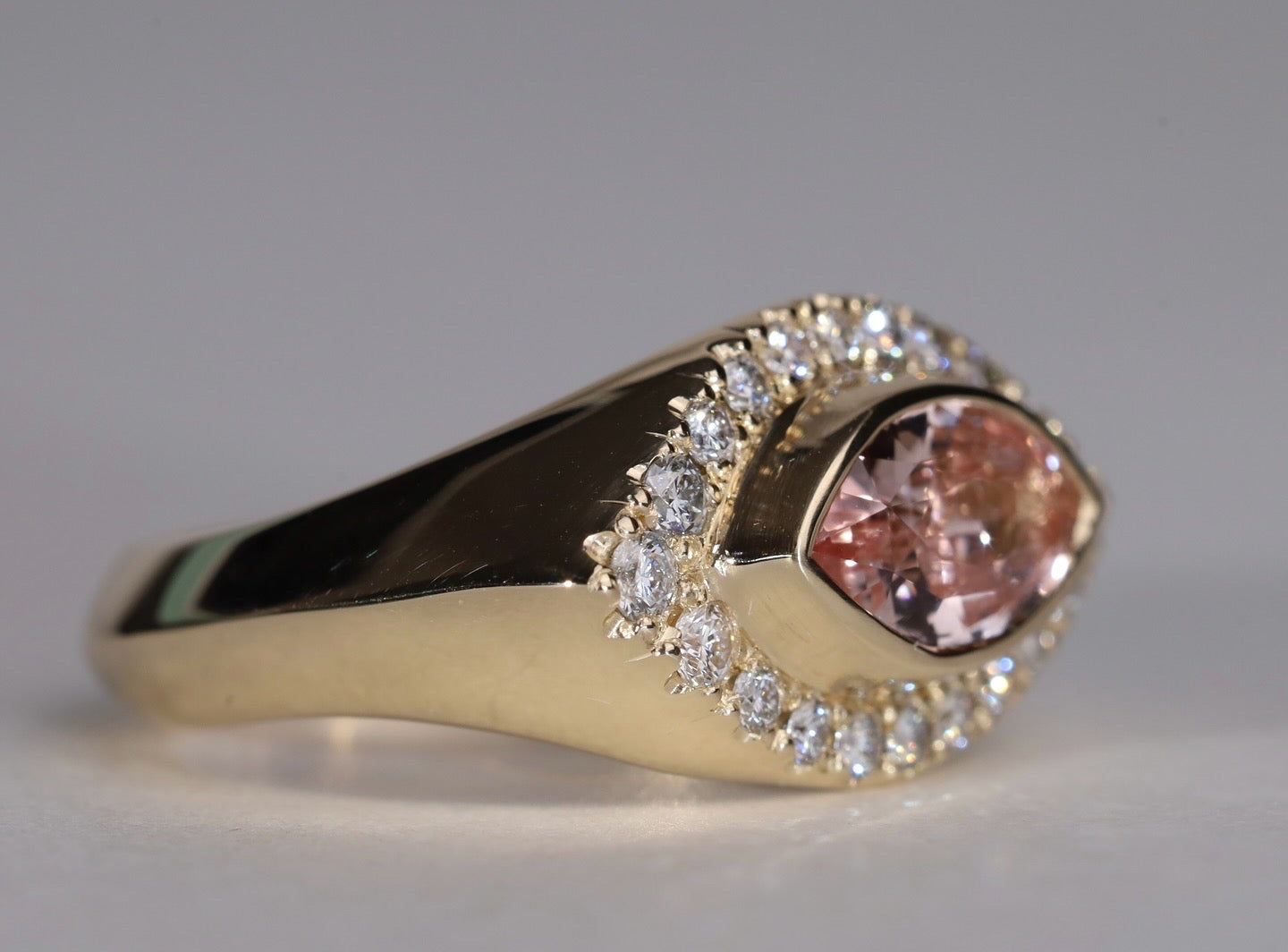 Gold ring with arquise cut sapphire surrounded by diamonds.