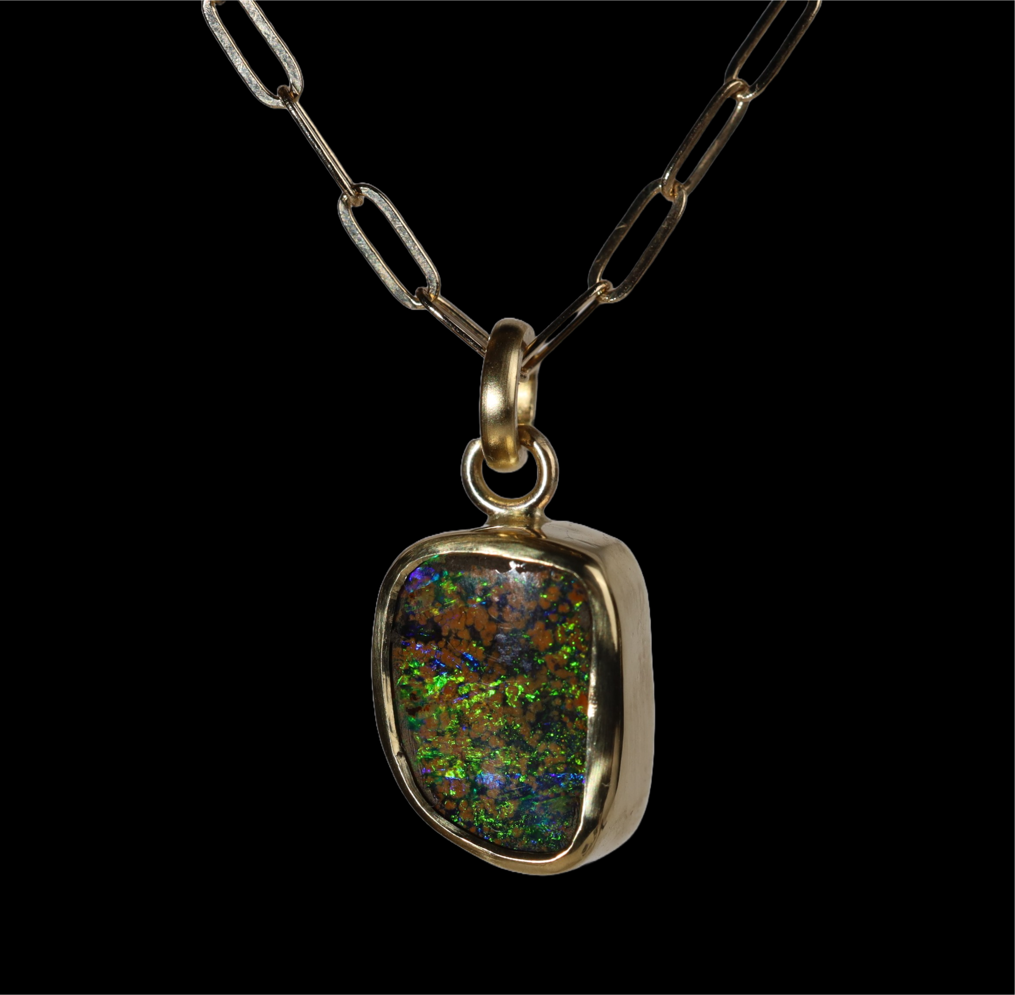 Front view of opal  pendant with green and blue sparkle and mustard spots.