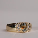 Gold ring with central particolor sapphire with a band of orange in green, flanked by diamonds.