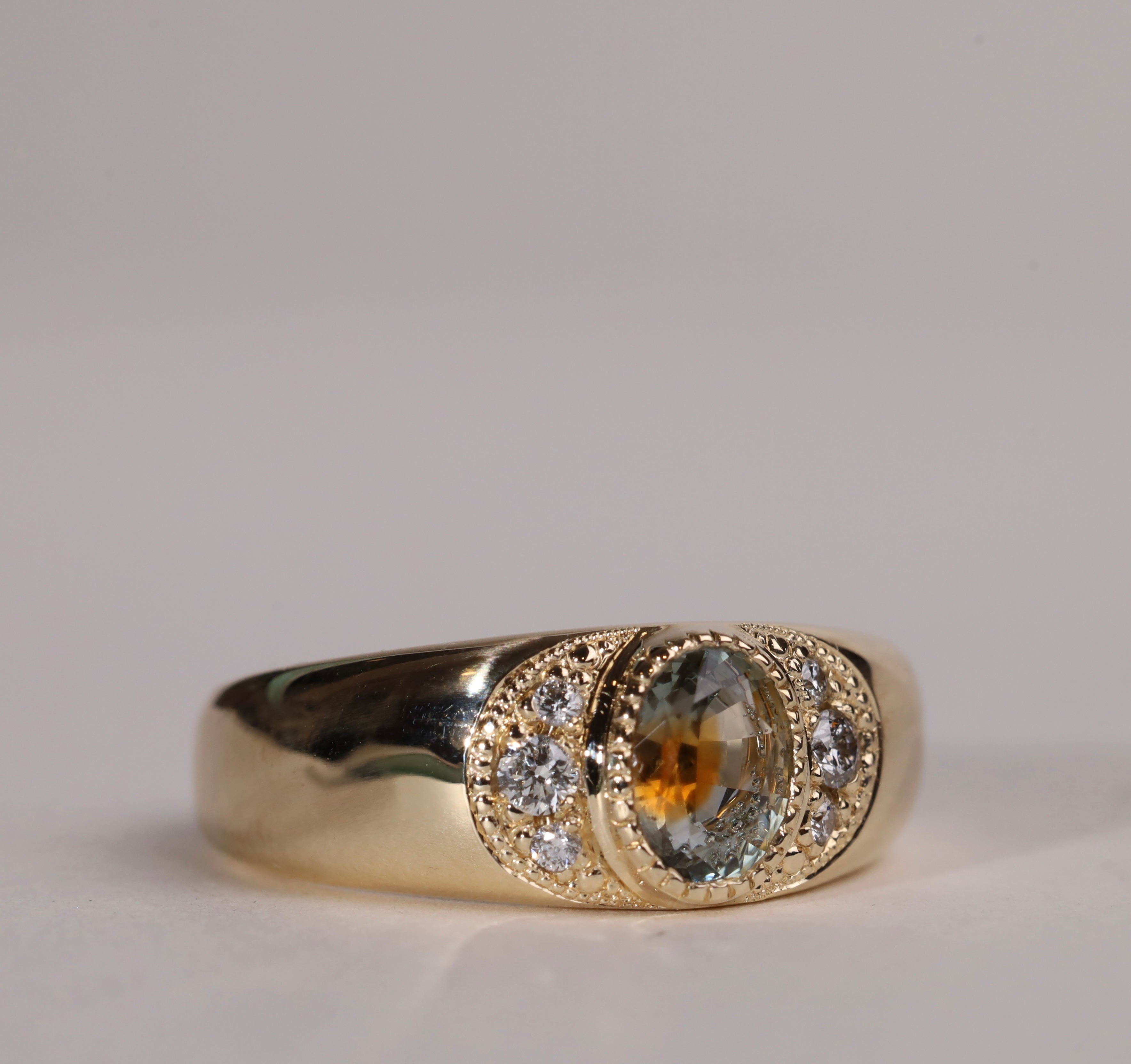 Gold ring with central particolor sapphire with a band of orange in green, flanked by diamonds.