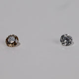 Shot of pair of diamond, champagne diamond on left and white diamond on right.