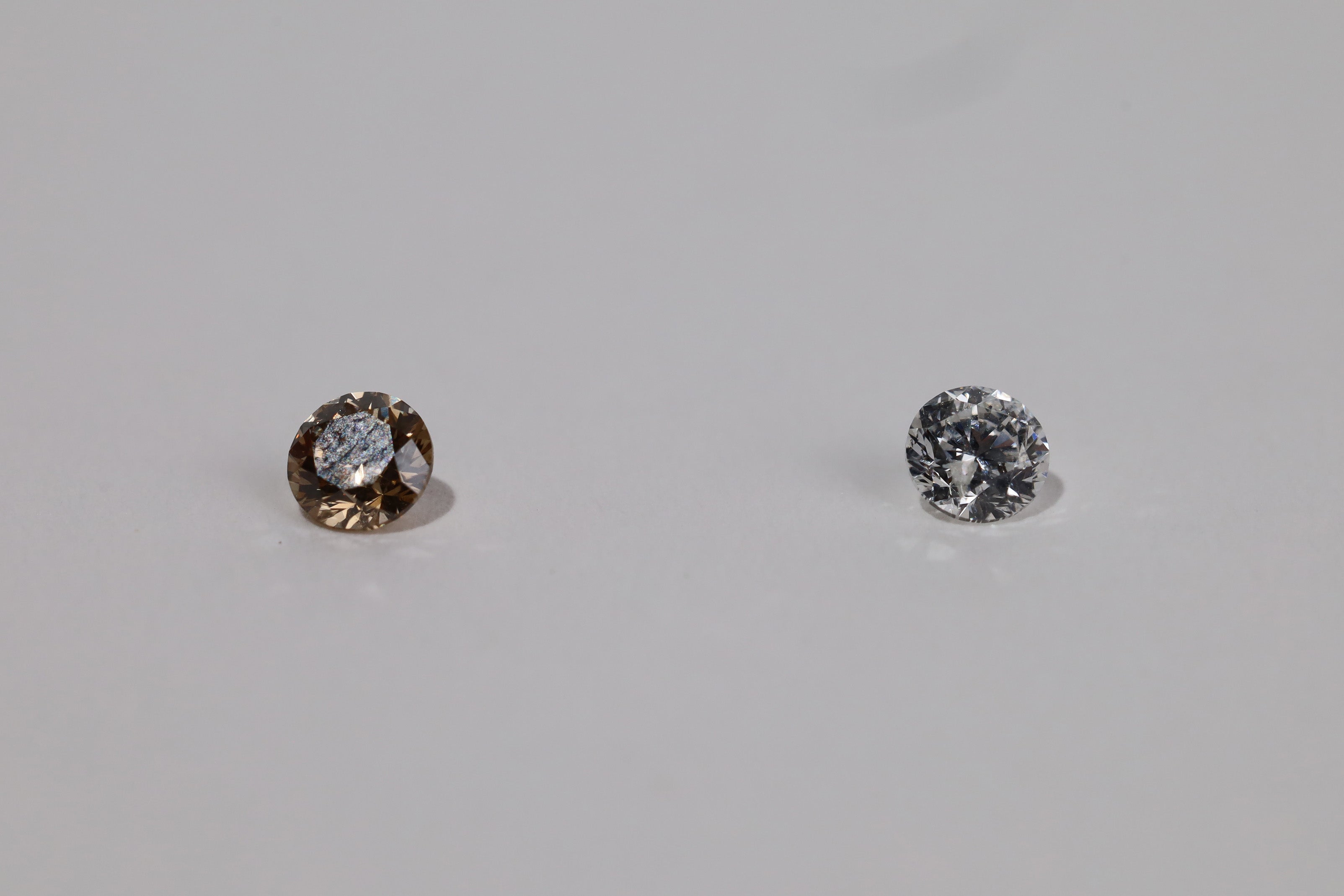 Shot of pair of diamond, champagne diamond on left and white diamond on right.