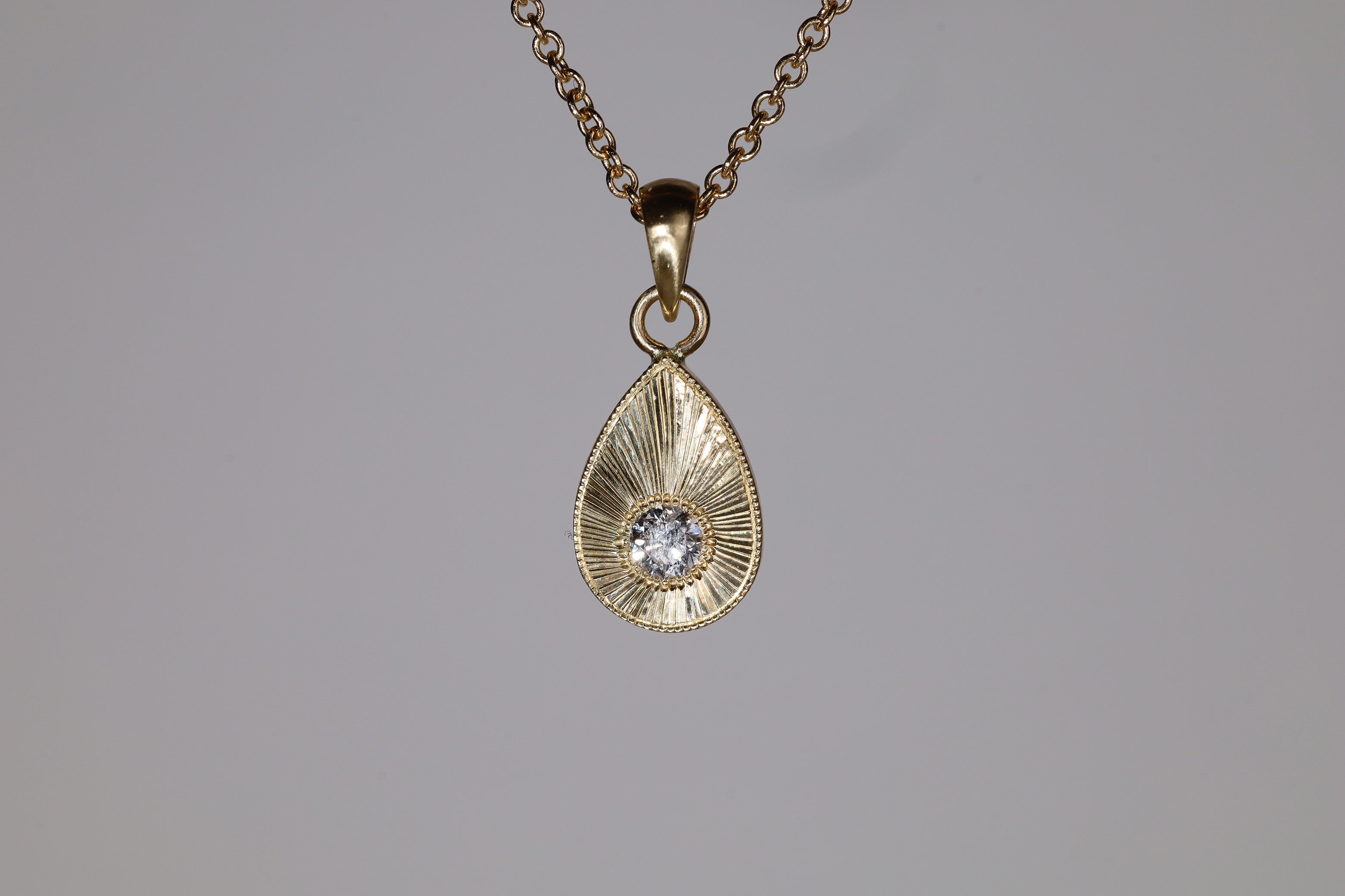 White diamond plume charm example hanging from a 14k chain that is available separately. 