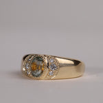 Gold ring with central particolor sapphire with a band of orange in green, flanked by diamonds.