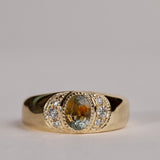 Gold ring with central particolor sapphire with a band of orange in green, flanked by diamonds.