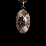 Front view of 14k yellow gold portal charm.  Tall oval shaped with central set blue marquise sapphire,  Three white diamonds on each side of the central stone  and engraved lines radiating up and down.