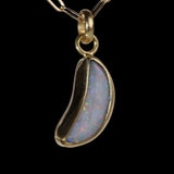 Front view of crescent shaped opal  pendant with red and blue sparkle.