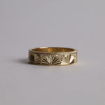 Gold band with fan shaped engraving encirling and small diamonds