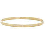 Full view of the 14k yellow gold bangle showing the diamonds set in engraved star settings around its perimeter.